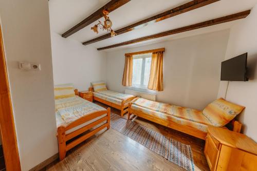 a room with three beds and a tv at Pensiunea Patakparti 2 in Praid