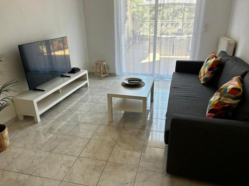 a living room with a couch and a tv at Villa Airelle in La Turbie