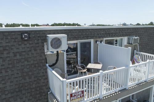 a balcony with a fan and chairs on a building at Town of Lewes --- 8 Georgia Ave. Unit 2 in Lewes
