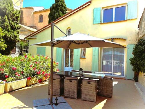 an umbrella sitting on a patio in front of a building at Villa Airelle in La Turbie