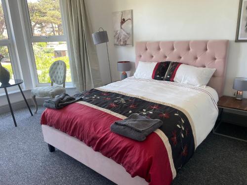 a bedroom with a large bed with a red blanket at Leamington Beech Villa in Penmaen-mawr