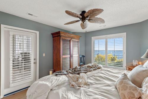 a bedroom with a bed and a ceiling fan at PC Beach in Manteo