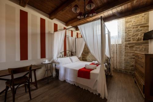a bedroom with a white bed with red and white stripes at Locanda Mammi in Agnone