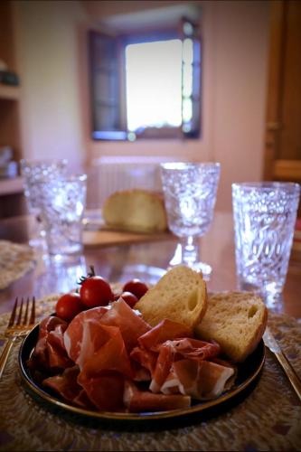 a plate of food with bacon and bread on a table at Romantic cozy house 15 min Arezzo piscina&bosco in Falciano