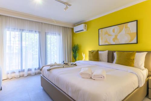 a bedroom with a large bed with yellow walls at CityZen - Boutique Studios in Achrafieh in Beirut