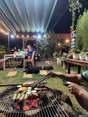 a group of people cooking food on a grill at Homestay Lưng Đồi in Buôn Dhă Prŏng