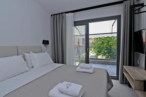 a bedroom with a large bed and a large window at Agios Nikolaos Villas in Ayios Nikolaos Sithonia