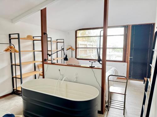 Cette chambre dispose d'une grande baignoire et de fenêtres. dans l'établissement Maison Starck, à Saint-Malo
