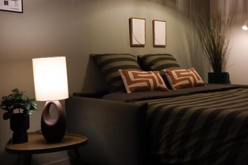 a bedroom with a bed and a lamp on a table at La Dune aux Argousiers in Wimereux - sleeps 4 in Wimereux