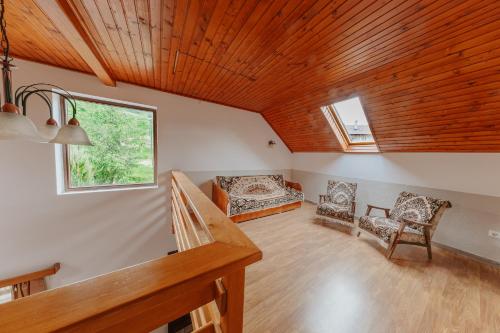 a living room with two chairs and a window at Pensiunea Patakparti 2 in Praid