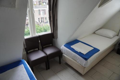 a small room with a bed and two chairs at Hotel Schroder in Amsterdam