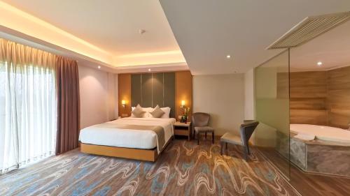 a hotel room with a bed and a bath tub at The Grandmark Dhaka in Dhaka