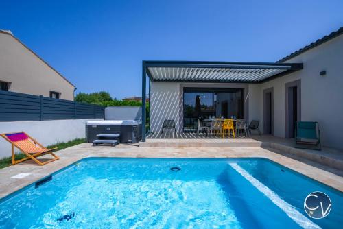 une piscine dans l'arrière-cour d'une maison dans l'établissement Villa moderne tout confort-Jacuzzi-Piscine, à Saint-Quentin-la-Poterie