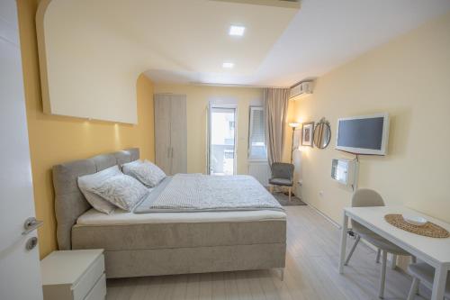 a small bedroom with a bed and a desk at Amber Apartman in Banja Koviljača