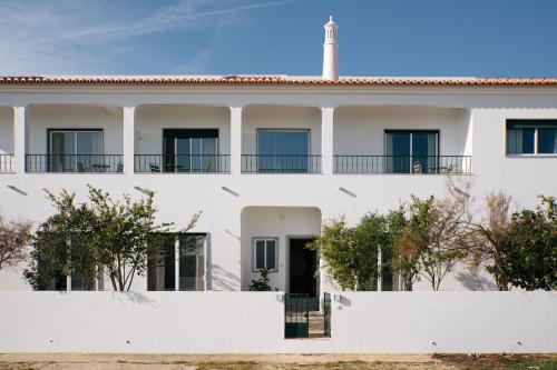 a white house with a white fence at Outsite Sagres in Sagres