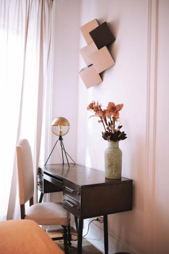 a desk with a vase of flowers on it in a bedroom at House Sao Bento in Lisbon