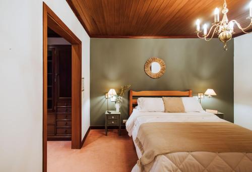 a bedroom with a large bed and a chandelier at Smart Hotel Reserva Campos do Jordão in Campos do Jordão