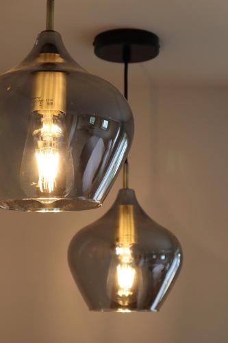 two glass lights hanging from a ceiling at 1 & 2 bedroom Weaver's Cottages at Frame Farm in Benenden