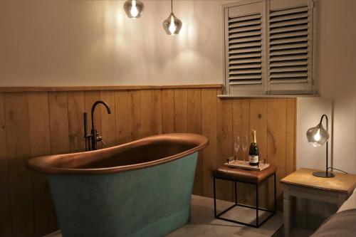 a bath tub in a room with a window at 1 & 2 bedroom Weaver's Cottages at Frame Farm in Benenden