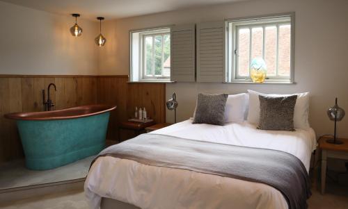 a bedroom with a tub and a bed and a bathtub at 1 & 2 bedroom Weaver's Cottages at Frame Farm in Benenden