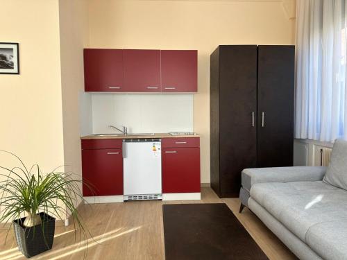 cocina con armarios rojos y nevera blanca en Hotel neue Traube, en Fellbach