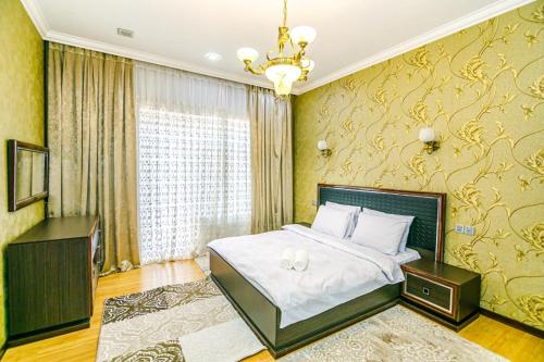 Un dormitorio con una cama grande y una lámpara de araña. en IMPEX Apartment, en Baku