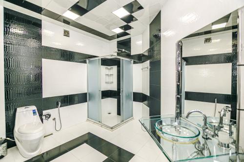 Un baño con lavabo de cristal y inodoro. en IMPEX Apartment, en Baku