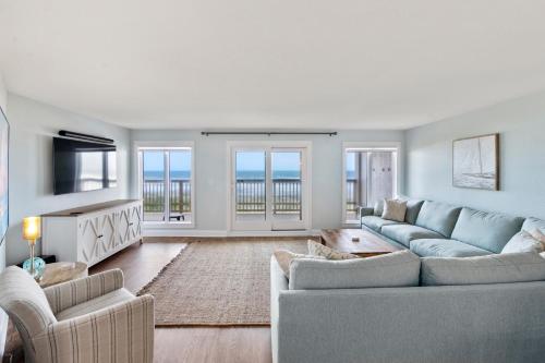 Una sala de estar con un sofá y un televisor. en Heron Cove 302N, en Nags Head