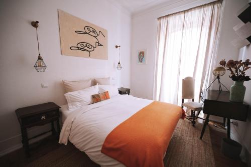 a bedroom with a bed and a desk and a window at House Sao Bento in Lisbon