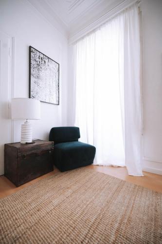 a living room with a green chair and a rug at House Sao Bento in Lisbon