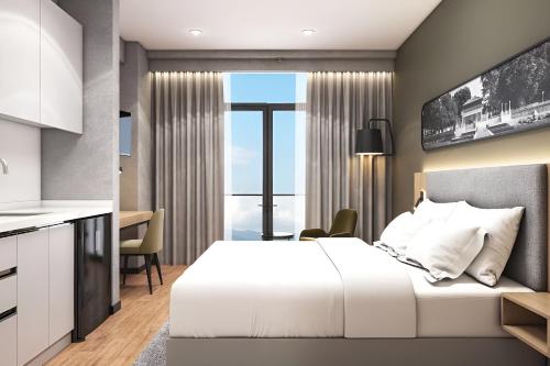 a bedroom with a white bed and a kitchen at Park Inn by Radisson Yalova City Center in Yalova