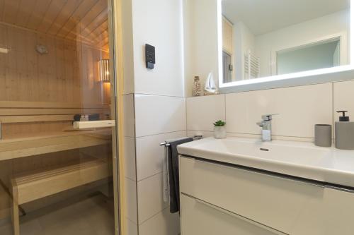 a bathroom with a sink and a mirror at Herz von Kellenhusen 8 - mit Sauna und Balkon, nur 300m vom Strand entfernt in Kellenhusen