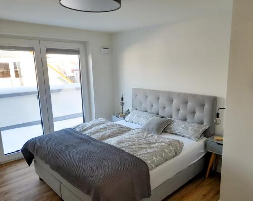 ein Schlafzimmer mit einem großen Bett mit einem großen Fenster in der Unterkunft Meerperle 2-0 mit Dachterrasse und Sauna in Kellenhusen