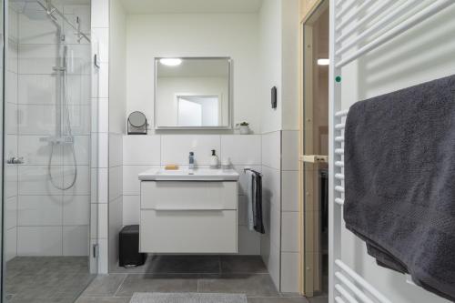 ein weißes Badezimmer mit Waschbecken und Dusche in der Unterkunft Ankerherz - besonders familienfreundlich, Hunde willkommen! in Kellenhusen