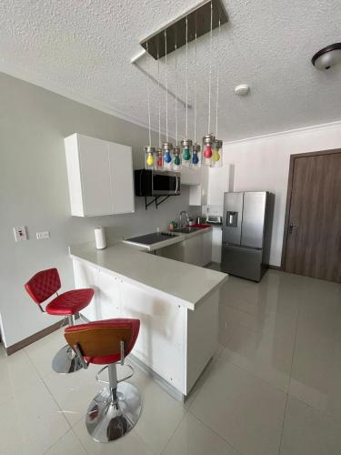 a kitchen with two red chairs and a counter at Joy Luxury Estate Kingston in Kingston