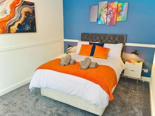 a bedroom with a bed with an orange blanket at Ideal 4 Bed Home sleeps 7 Nr Middlebrook Stadium in Lostock