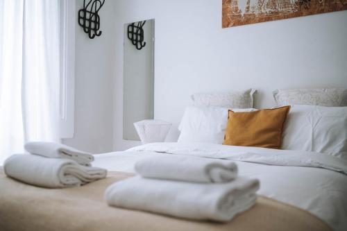 a bedroom with a white bed with towels on it at House Sao Bento in Lisbon