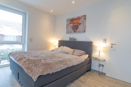 a bedroom with a bed and a window and two lamps at Ferienwohnung Suite Relax - nur 3 Minuten vom Strand entfernt in Scharbeutz