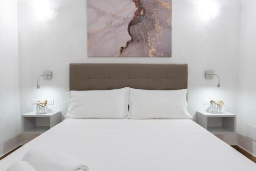 a bedroom with a large white bed with two night stands at AHR Residence Porto Pollo in Porto Pollo