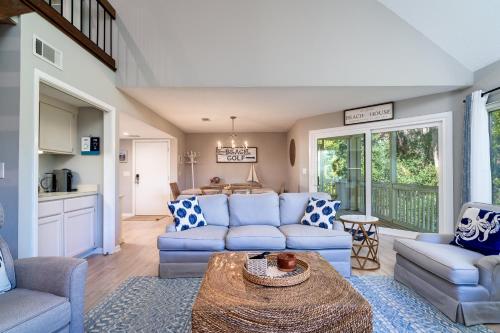 a living room with blue couches and a table at 778 Spinnaker Beach House in Seabrook Island