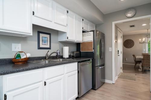 a kitchen with white cabinets and a stainless steel refrigerator at 778 Spinnaker Beach House in Seabrook Island