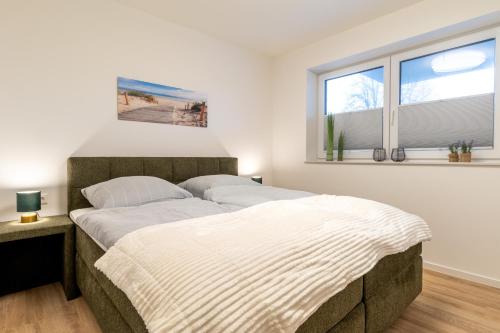 Una cama o camas en una habitación de Dorumer Sielhuus 2 - Ferienwohnung mit Terrasse und Sauna