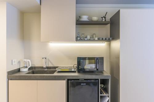 a kitchen with a sink and a microwave at CityZen - Boutique Studios in Achrafieh in Beirut