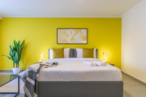 a bedroom with a large bed with yellow walls at CityZen - Boutique Studios in Achrafieh in Beirut