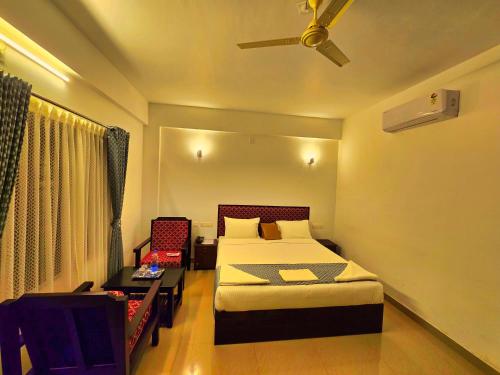 a bedroom with a bed and a table and a ceiling fan at Green BOB Villa in Sultan Bathery