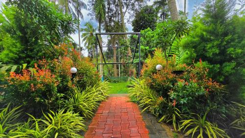 a garden with a gate and a brick walkway at Green BOB Villa in Sultan Bathery