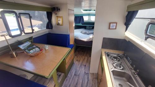 une petite cuisine avec un évier et une machine à laver dans l'établissement Bateau à quai lac des Settons, à Montsauche