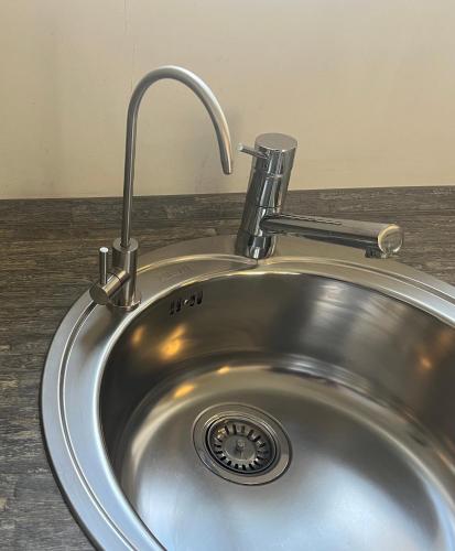 a stainless steel sink with a faucet on a counter at Longevity Box in Potsdam