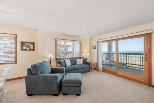 una sala de estar con un sofá y una silla en Heron Cove 304S, en Nags Head