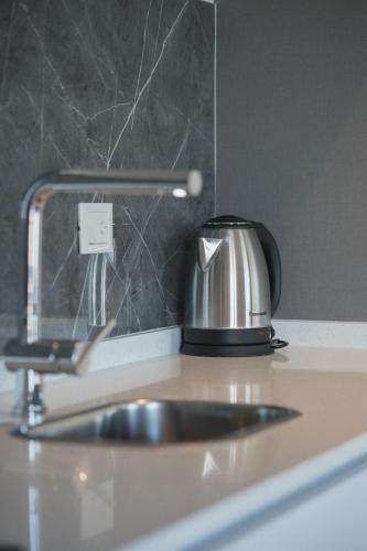 a kitchen counter with a sink and a tea kettle at Rayentray Puerto Piramides in Puerto Pirámides